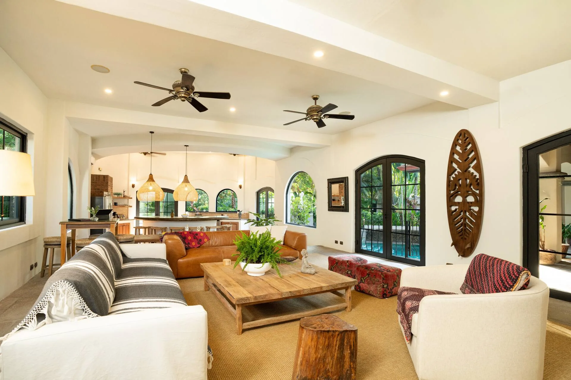 The great room with leather sofa and arched doors to the pool