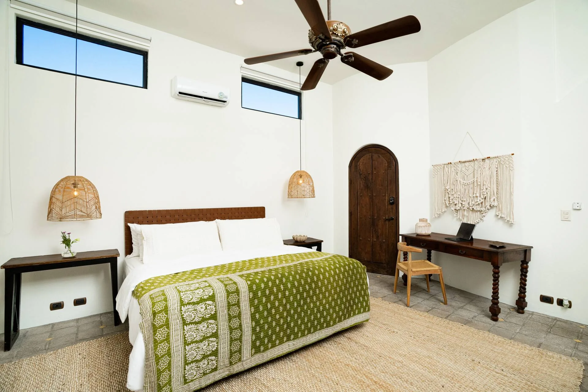Master bedroom with king bed and green throw
