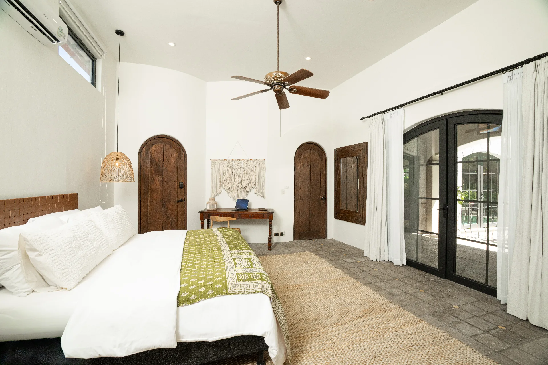 Master suite — wide view with arched doors and vaulted ceiling
