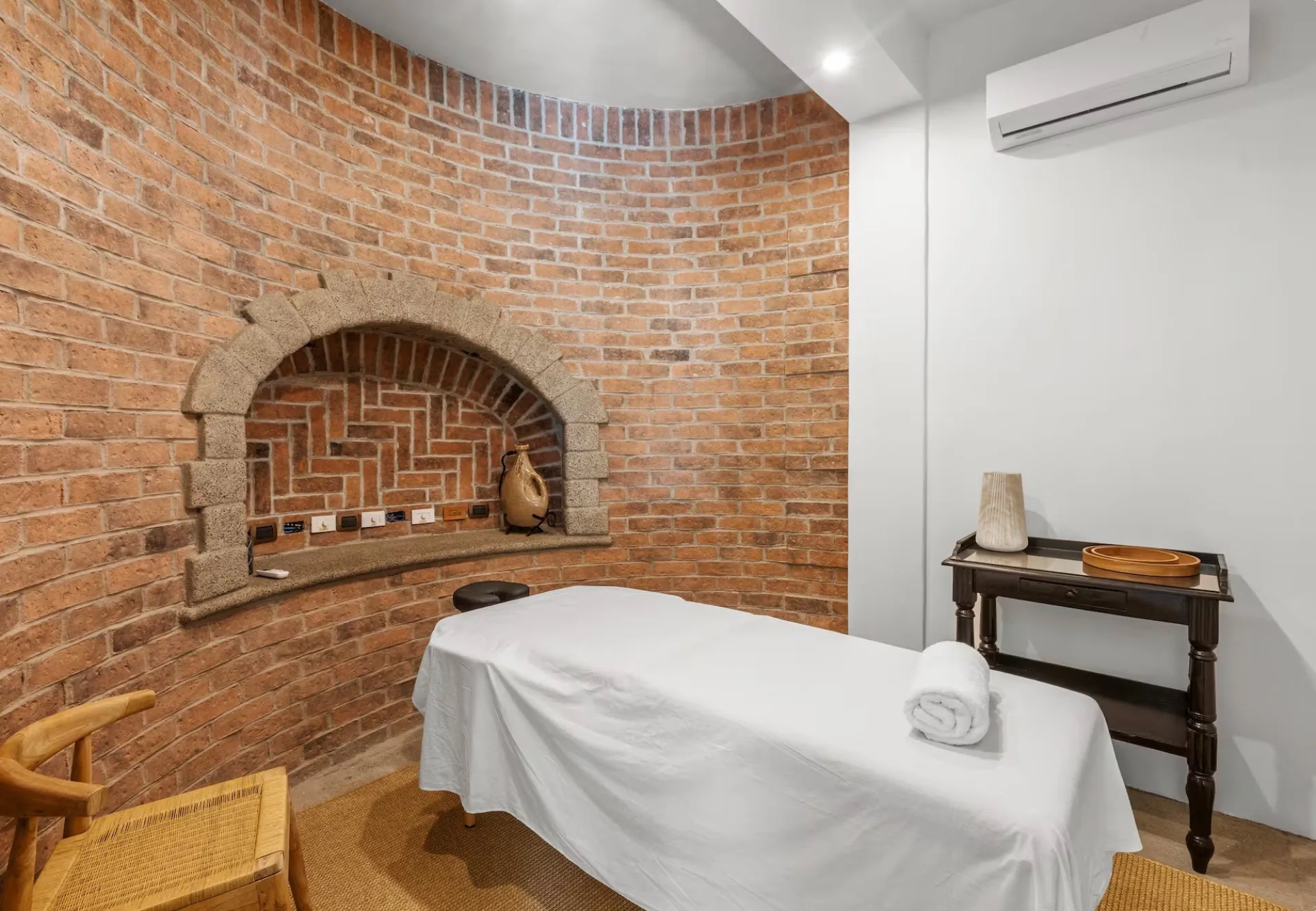In-house massage room with exposed brick wall