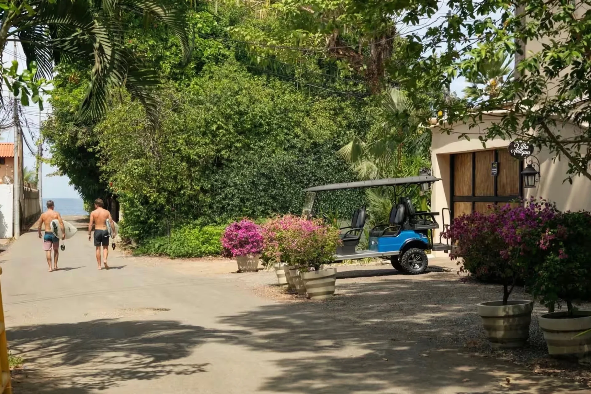 Surfers walking from Villa Antigua's gate down to the beach